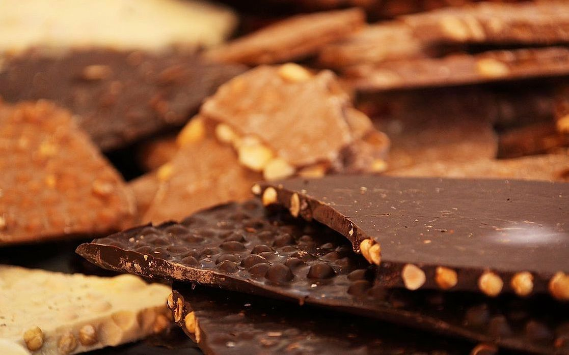 Una barra de chocolate oscuro con textura rústica y brillo intenso